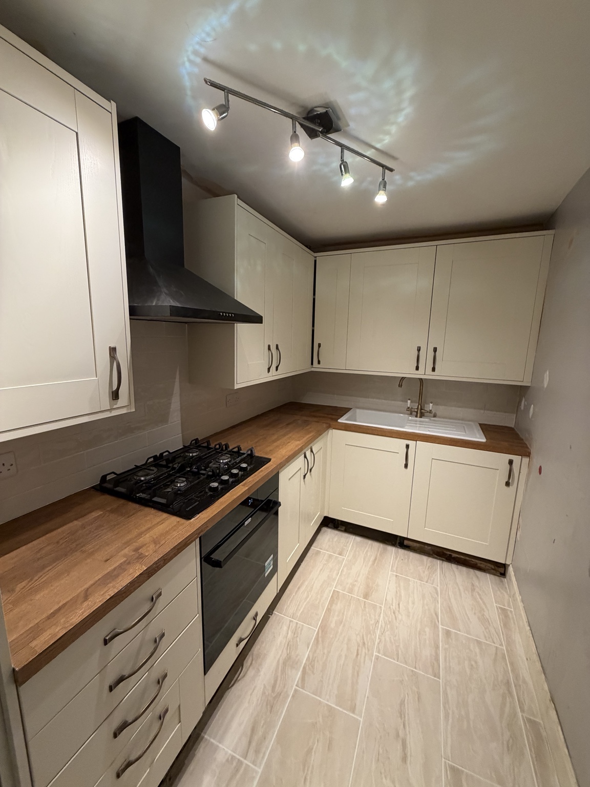 Kitchen installation with cream cabinetry and timber worktops